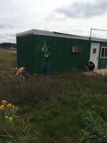 Students painting over the former office house